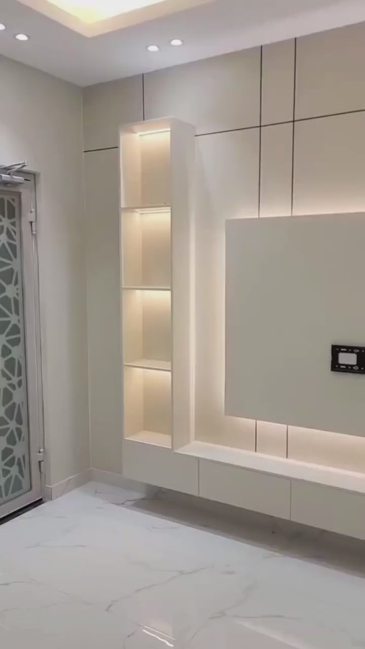 Modern LED işıqlı TV ünitesi, beyaz renkli, gömme raflar ve aydınlatmalı bölmeler, şık ve fonksiyonel oturma odası mekanı